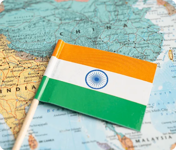 Small Indian flag on a stick resting on a map showing India and neighboring countries