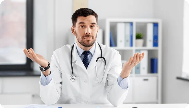 Doctor in white coat with stethoscope shrugging with open palms at a desk