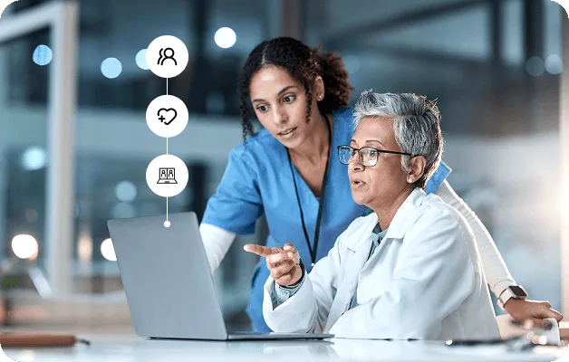 full-time-equivalent-fte-model image 61056 webp Nurse in blue scrubs and senior doctor in white coat looking at a laptop together