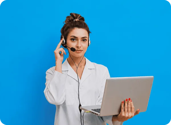 Woman in white coat with headset holding a laptop against a bright blue background
