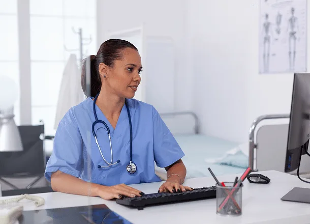 Healthcare staff member entering billing data at a computer