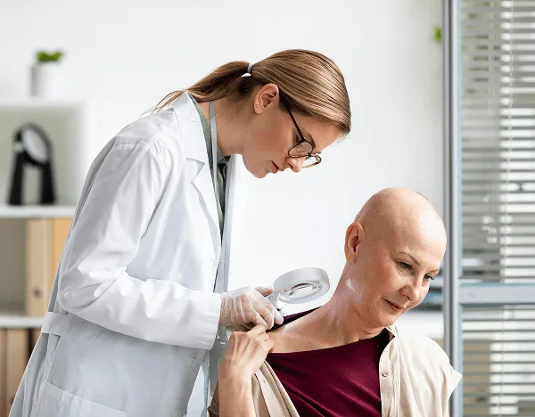 Doctor in a white coat examines a patient's shoulder skin with a magnifying glass