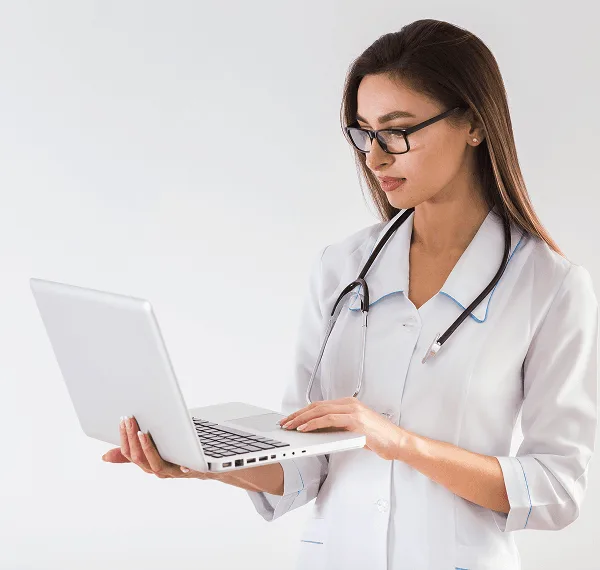 Woman in white coat with stethoscope and glasses holding an open laptop
