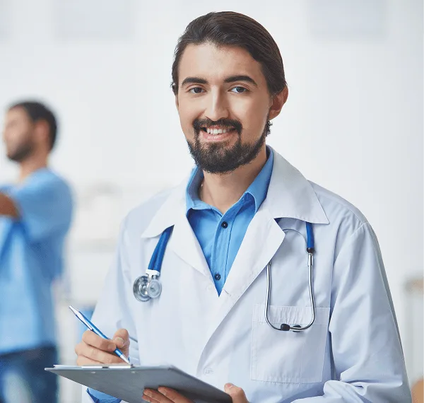 Smiling doctor in a white coat with a stethoscope holds a clipboard and pen