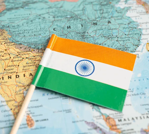 Small Indian flag on a printed map showing India and Southeast Asia