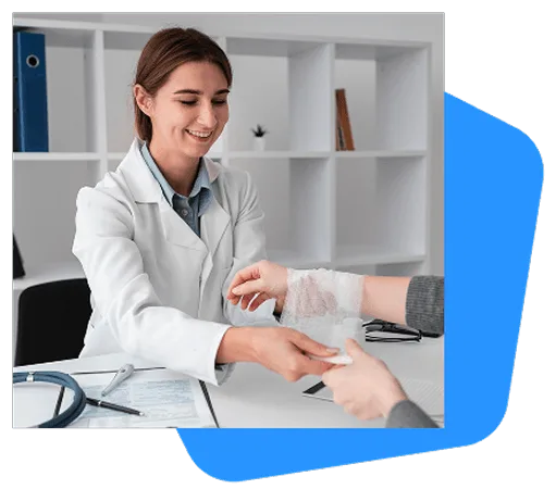 wound-care image 59156 webp Smiling woman in white coat handing a bandage to a patient whose wrist is wrapped, at a desk