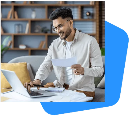 wound-care image 59173 webp Smiling bearded man with glasses holding a paper and writing near an open laptop on a sofa